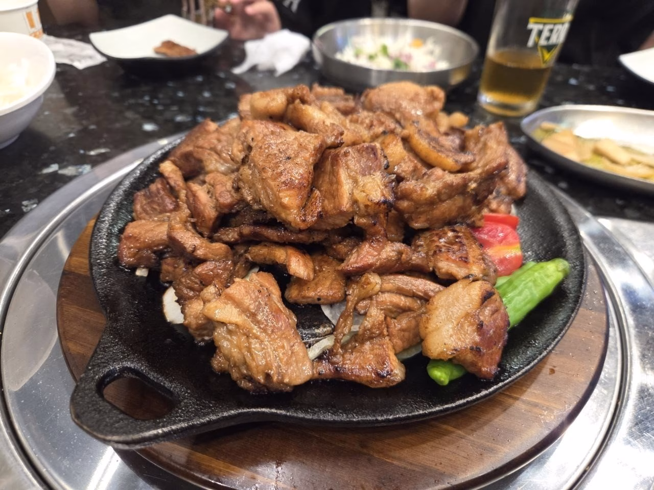 철판에 담겨 나온 양념 돼지갈비와 풋고추
